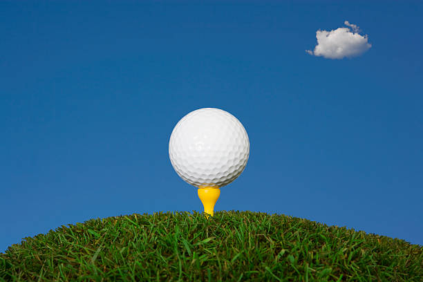 istock Golf ball on tee against blue sky 114251742