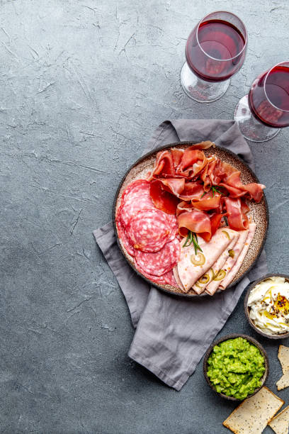 istock Antipasto. Meat platter, chips and sauces, red wine on gray background. Top view 1142520422