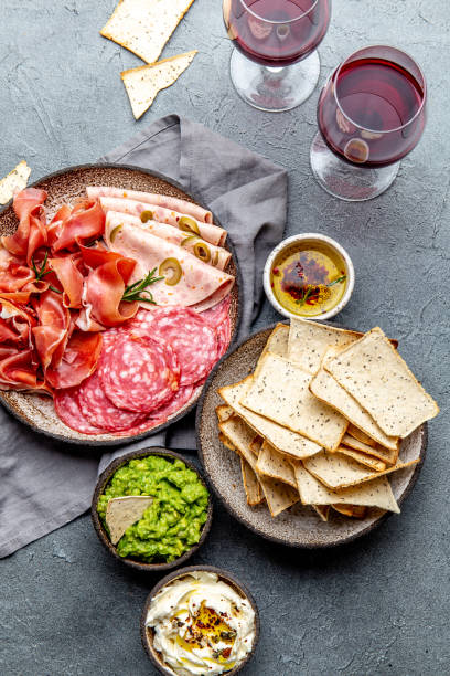 istock Antipasto. Meat platter, chips and sauces, red wine on gray background. Top view 1142520423