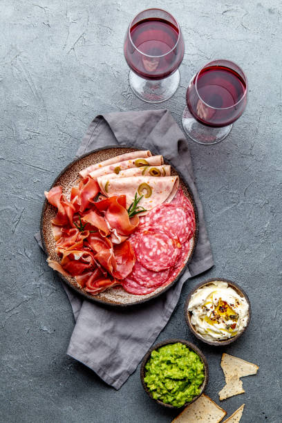 istock Antipasto. Meat platter, chips and sauces, red wine on gray background. Top view 1142520427