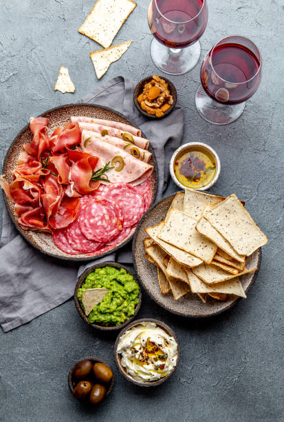 istock Antipasto. Meat platter, chips and sauces, red wine on gray background. Top view 1142520428