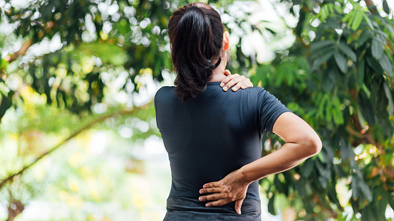 Las mujeres jóvenes asiáticas con dolor de espalda, concepto de atención médica photo