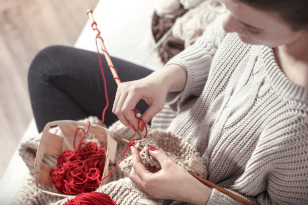 woman knits knitting needles on the couch