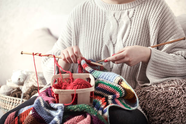 istock woman knits knitting needles on the couch 1142533526