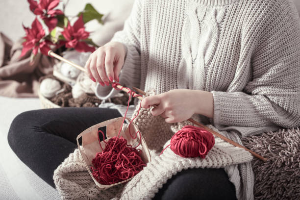 istock woman knits knitting needles on the couch 1142533528