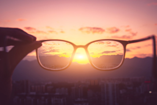 Looking city sunset through eyeglass