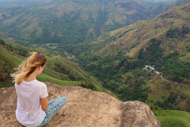 istock Woman sitting on a rock 1142535303
