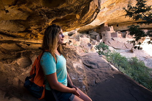 Teenage girl lost in thought while visitng the Cliff Palace cliff dwelling inhabited until the 13th century by  Ancient Puebloans (Anasazi), Mesa Verde National Park, Colorado, USA