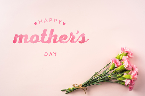 event design concept - top view of a bunch of pink carnation with greeting word on pink background for mothers day event with copy space for mock up