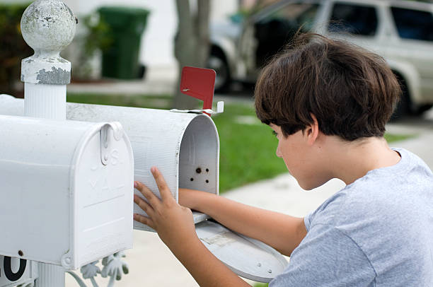 bambino con la mano all'interno di una cassetta postale - mailbox mail junk mail opening foto e immagini stock