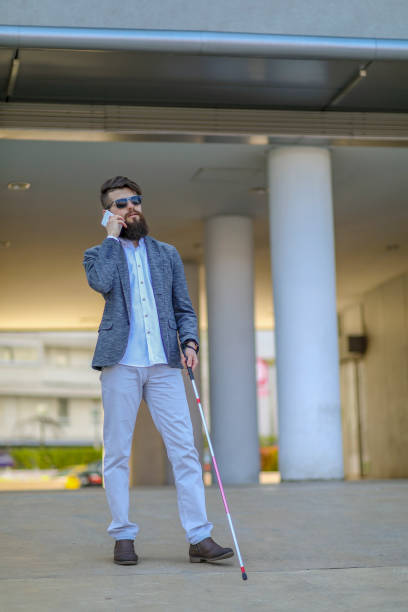 istock Blind and bearded man with a walking stick on the street 1142551637