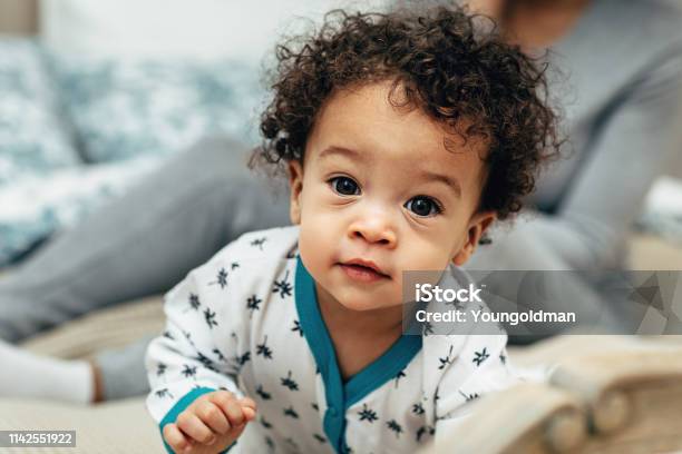 Close Up Portrait Of A Curlyhaired Baby Boy Crawling On Bed Stock Photo - Download Image Now
