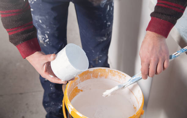 istock Man hands paintbrush with white paint. Renovation 1142554786