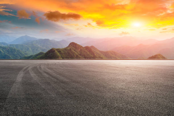 istock Asphalt race track ground and mountain with sunset clouds 1142558530