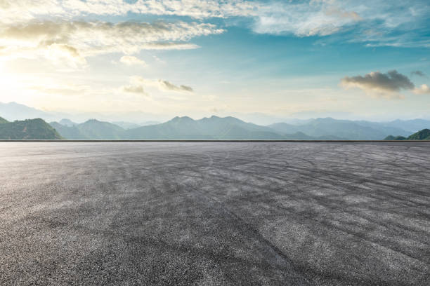 istock Asphalt race track ground and mountain with sunset clouds 1142558565