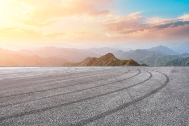 istock Asphalt race track ground and mountain with sunset clouds 1142558682