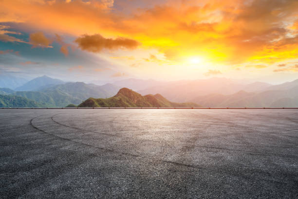 istock Asphalt race track ground and mountain with sunset clouds 1142558693