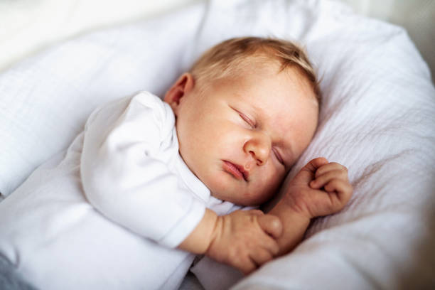 家で眠っている生まれたばかりの赤ん坊のクローズアップ。 ストックフォト