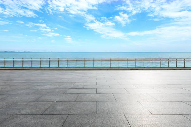 istock Empty square floor and blue lake with sky clouds 1142559412
