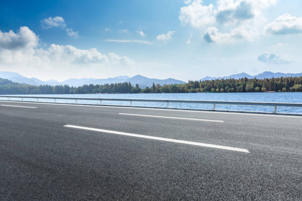 istock Asphalt road and mountains with lake landscape 1142559496