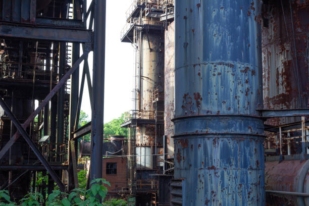 istock Greenery growing up through an abandoned industrial complex, peeling paint and rusted pipes 1142559687