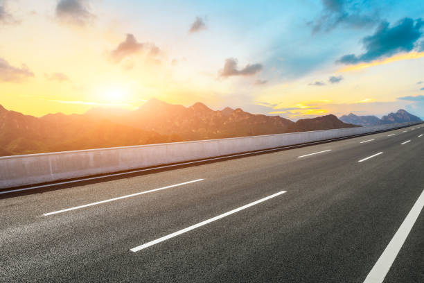 istock Asphalt road and mountains with beautiful clouds at sunset 1142559887