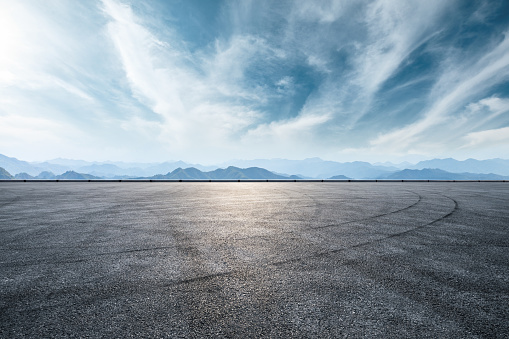 Asphalt race track and mountain with clouds background