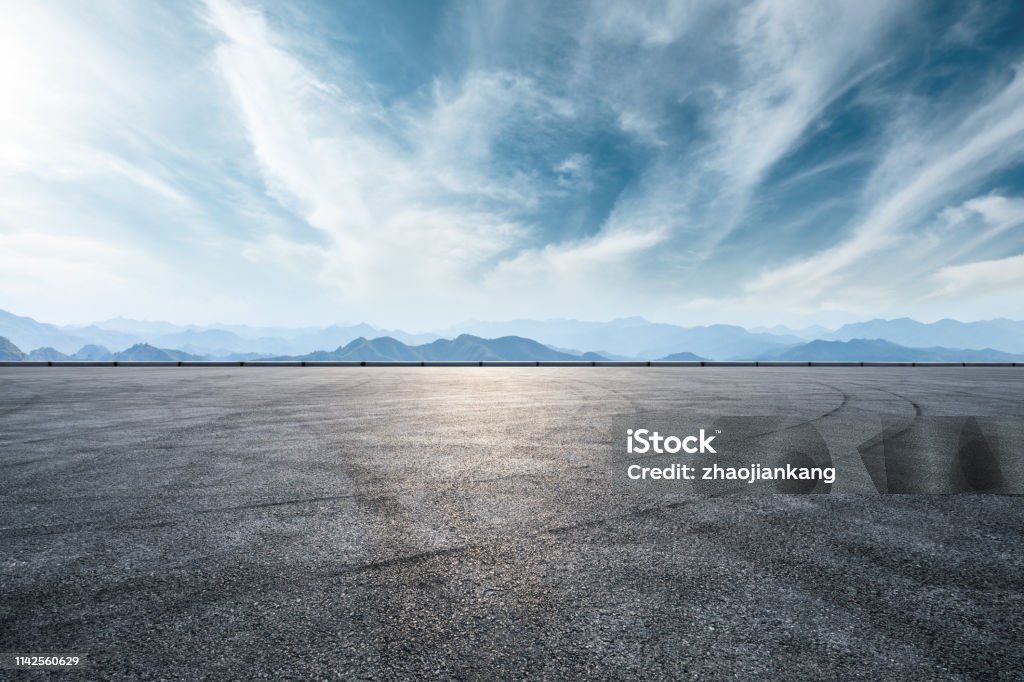 Asphalt race track and mountain with clouds background Asphalt race track ground and mountain with clouds background Road Stock Photo