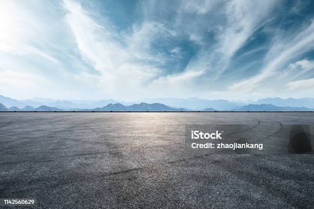 Asphalt Race Track And Mountain With Clouds Background Stock Photo - Download Image Now