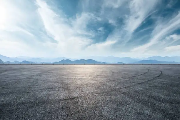 Asphalt race track ground and mountain with clouds background