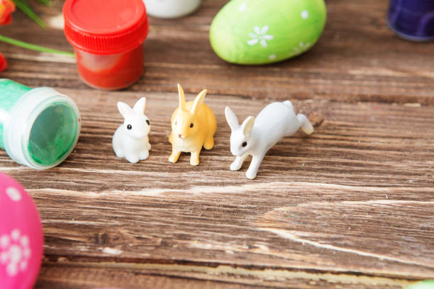 Easter eggs and Easter rabbits toys with flower on a wooden table.