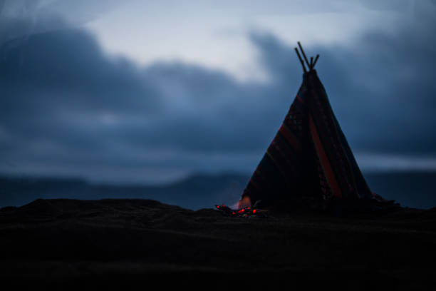 Artwork decoration creative concept. An old native american teepee in desert at the evening. Wigwam house indian style.