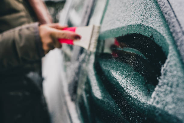 ein frostiges fenster auf einem auto putzen. - blizzard ice damaged snow stock-fotos und bilder