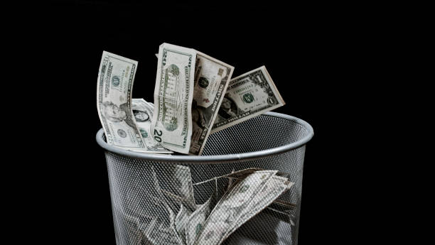 istock View of money falling into bin 1142578442