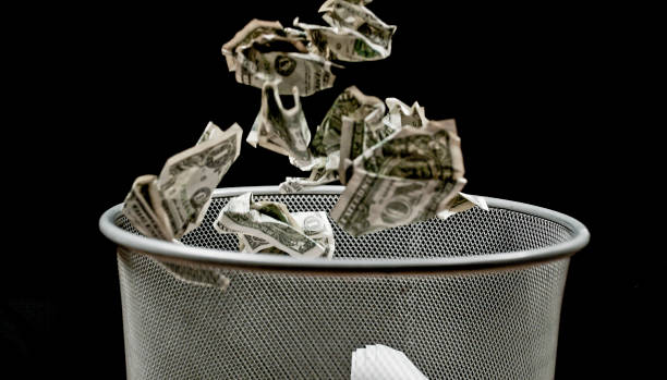 istock View of crushed money falling into bin 1142578444