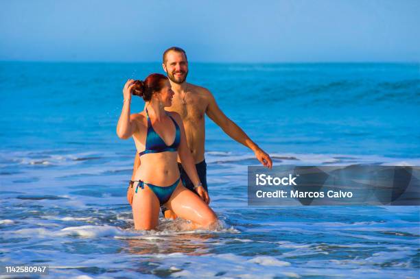 Young Happy And Beautiful Couple Enjoying Summer Holidays Travel Or Honeymoon Trip Together In Tropical Paradise Beach Having Fun Relaxed And Playful On The Sea Smiling Cheerful Stock Photo - Download Image Now