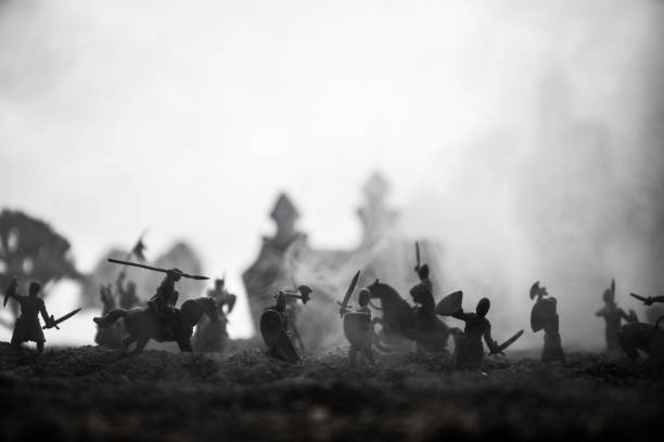 istock Medieval battle scene with cavalry and infantry. Silhouettes of figures as separate objects, fight between warriors on sunset foggy background. 1142581605