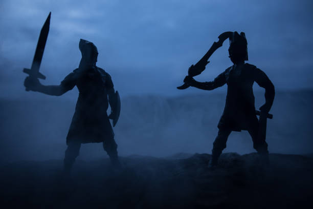 istock Medieval battle scene with cavalry and infantry. Silhouettes of figures as separate objects, fight between warriors on sunset foggy background. Artwork decoration. Selective focus 1142581610