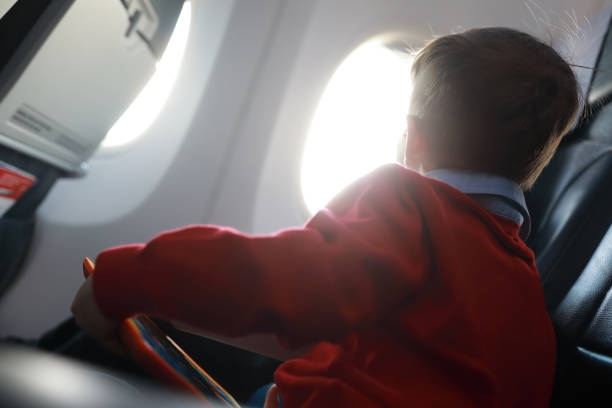 istock Child looks out window of plane 1142582063