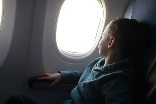 istock Boy looks out window of plane 1142582148