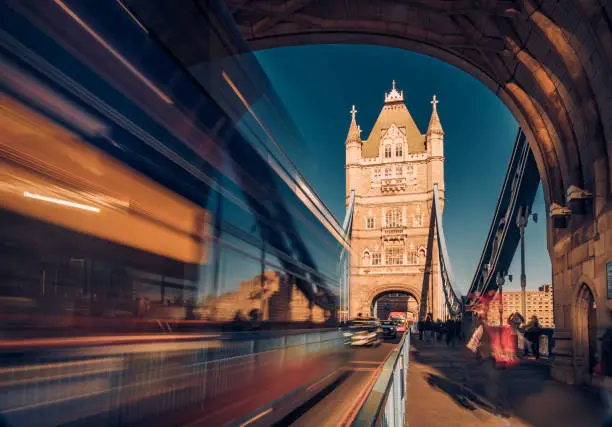 Beautiful long exposure with blurred motion at Tower Bridge in City of London, England. Dragged exposure technique to capture the busy road traffic and constant tourist (unrecognisable people) visiting this famous international landmark, connecting City of London directly to the Southwark bank (Unesco heritage site nowadays and build in 1894) . Shot on Canon EOS R full frame system with premium RF lens for highest quality results from a tripod. Toned edit.