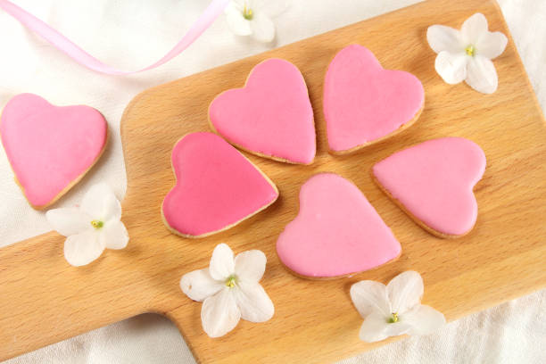 istock Pretty  girlish flat lay style with gently pink hearts biscuits cookies with white violets blooming flowers and satin ribbon top view.14 february valentine's day gift treat 1142584687