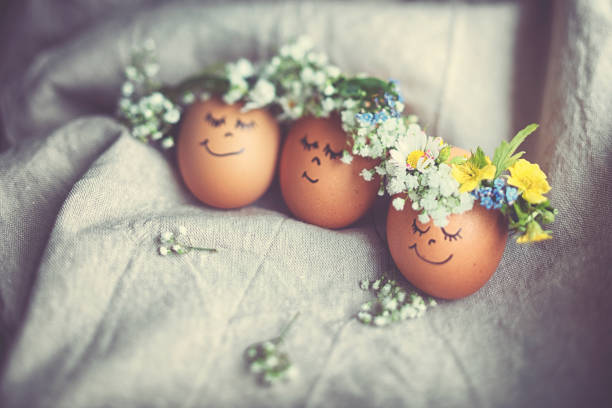 istock Natural easter eggs with funny painted face and sweet flower wreath 1142584752