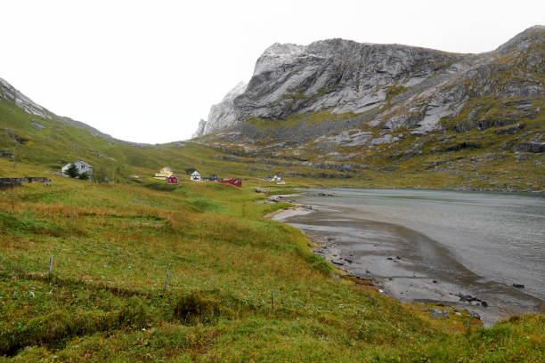 vista panorámica sobre un pequeño pueblo en la costa con una playa y las montañas circundantes en el camino a la playa de bunes en las islas lofoten en noruega. - 24409 fotografías e imágenes de stock