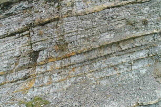 istock Cliff close-up view. Gray and yellow rock texture with small rocks. 1142586542