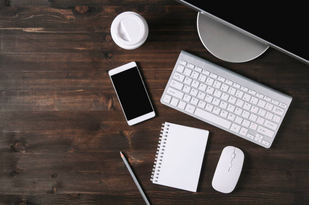 White keyboard, mouse and Notepad on wooden background. Flat lay and top view