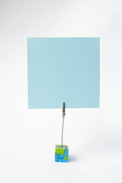 istock Note sheet inscriptions. Pink, blue, filet paper on a clothespin holder on white background, text space. Place for inscription. 1142587856