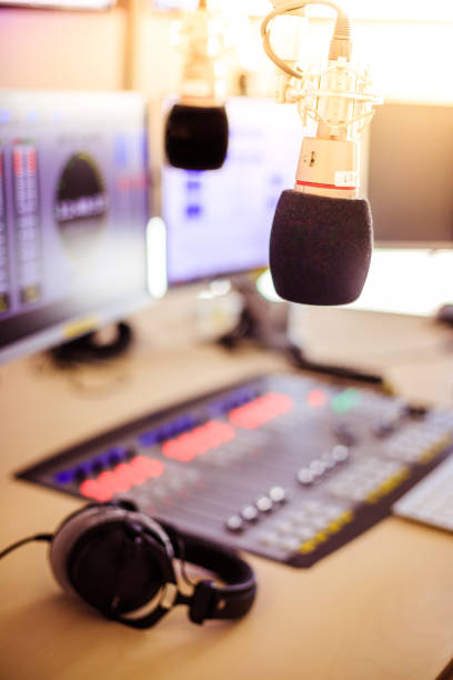 istock Radio broadcasting studio: Microphone in the foreground, modern studio in the blurry background 1142589862