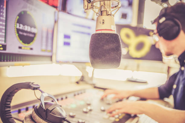 istock Radio moderator is sitting in a modern broadcasting studio and talking into the microphone 1142589875