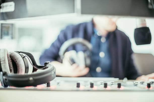istock Radio moderator is sitting in a modern broadcasting studio and talking into the microphone 1142589886